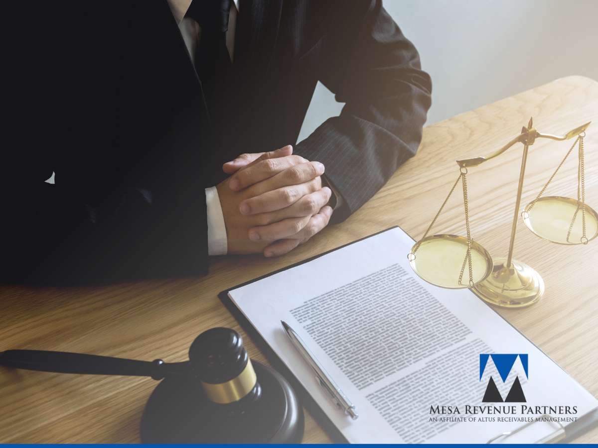 Lawyer sitting at a desk with scales of justice, representing initiating collections litigation.