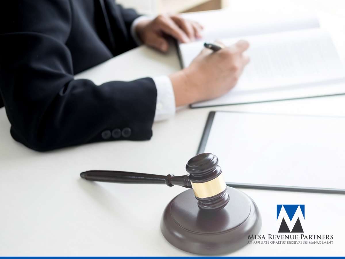  Debt Recovery professional signing legal documents with a gavel on the desk, representing Mesa Revenue Partners